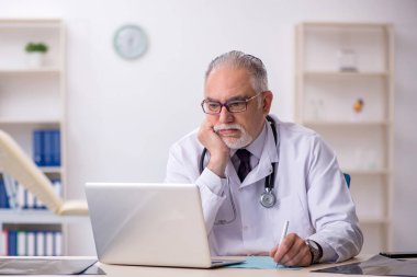 Hastanede çalışan yaşlı erkek doktor.