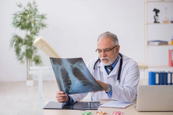 Starý lékař radiolog pracující na klinice — Stock fotografie