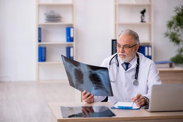 Gammal manlig röntgenläkare som arbetar på kliniken — Stockfoto