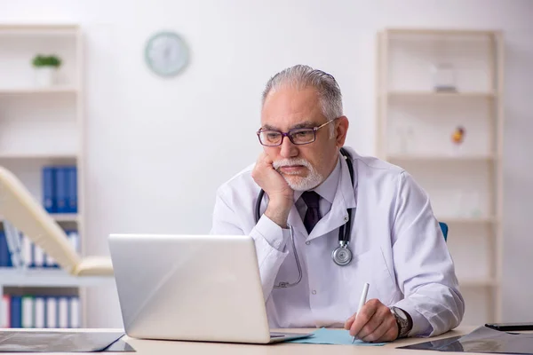 Old male doctor working at the hospital — Stock Photo, Image