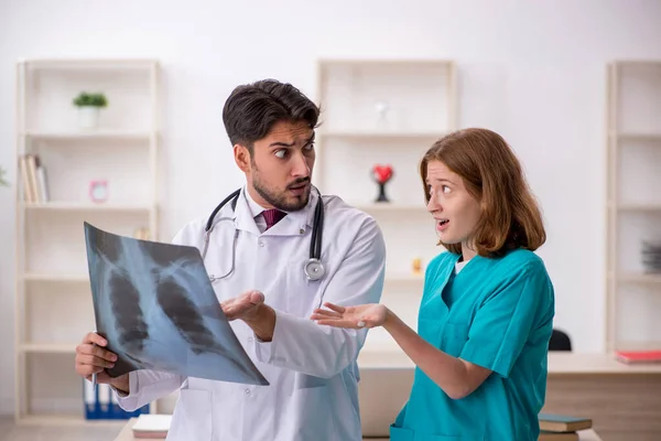 Ung manlig läkare radiolog och kvinnlig assistent arbetar i th — Stockfoto