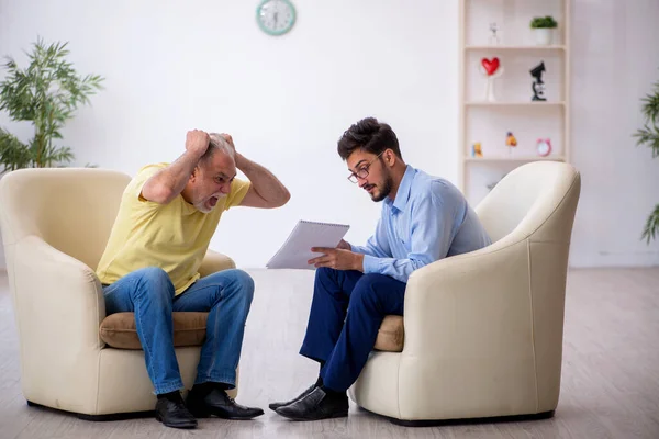 Old man visiting young male psychotherapist — Stock Photo, Image