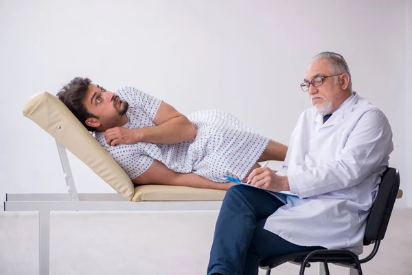 Old male doctor psychiatrist examining young male patient