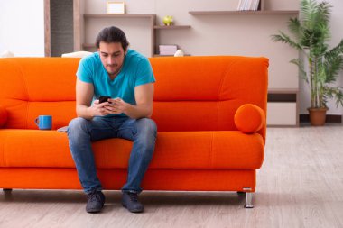 Genç erkek öğrenci salgın sırasında evde oturuyor.