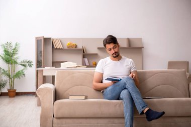 Genç erkek öğrenci salgın sırasında evde çalışıyor.