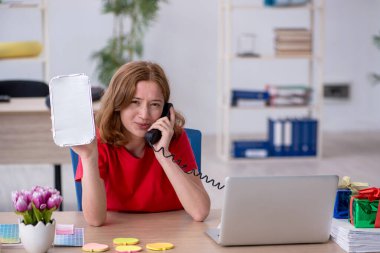 Genç bayan tasarımcı ofiste kahvaltı yapıyor.