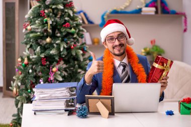 Genç işadamı Noel arifesinde evden çalışıyor.