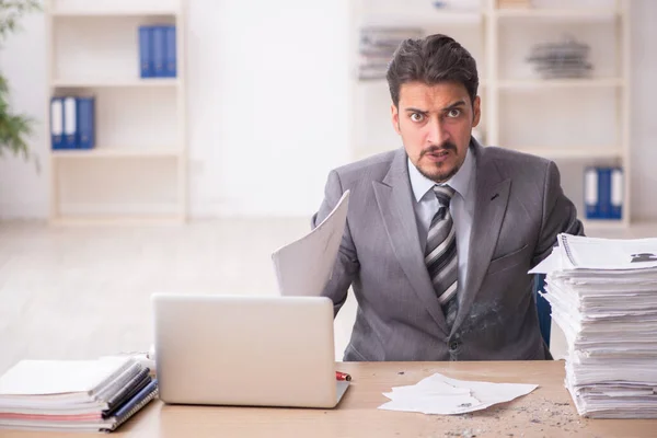 Jovem funcionário masculino infeliz com excesso de trabalho no escritório — Fotografia de Stock