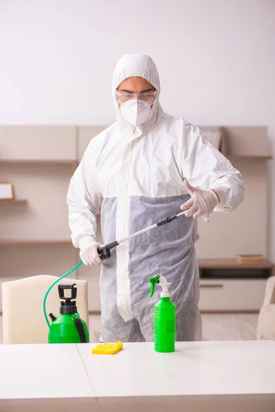 Jovem empreiteiro fazendo controle de pragas em casa — Fotografia de Stock