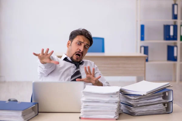 Junge männliche Mitarbeiter und zu viel Arbeit im Büro — Stockfoto