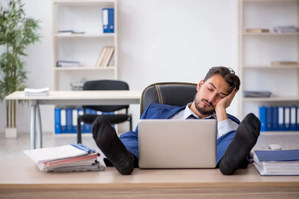 Jovem funcionário masculino extremamente cansado no escritório — Fotografia de Stock