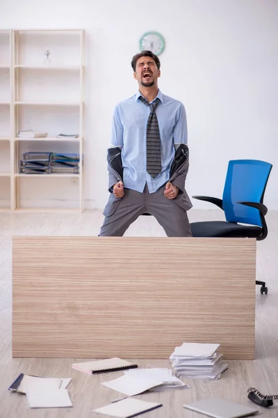 Jeune employé masculin effectuant des heures supplémentaires au bureau — Photo