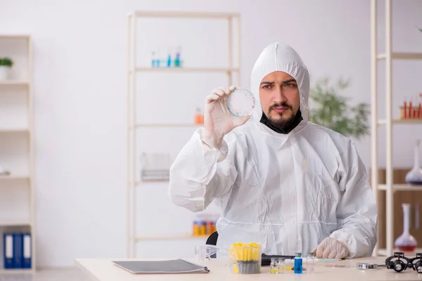 Joven químico trabajando en el laboratorio durante una pandemia — Foto de Stock