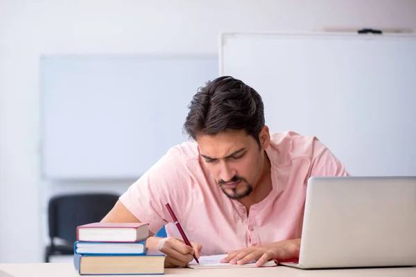 Jovem estudante se preparando para exames em sala de aula — Fotografia de Stock