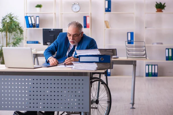 Alte männliche Angestellte im Rollstuhl sitzt im Büro — Stockfoto