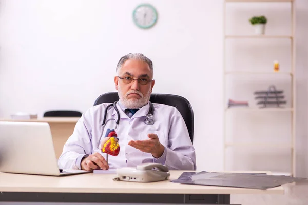 Klinikte çalışan yaşlı bir erkek kardiyolog. — Stok fotoğraf