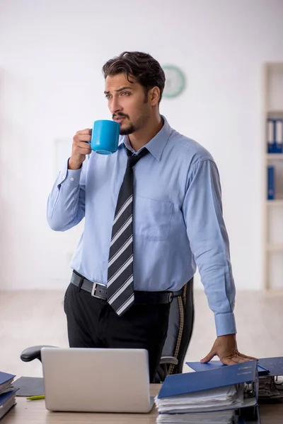 Junge männliche Angestellte trinkt in der Pause Kaffee — Stockfoto