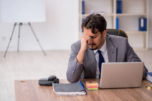 Junge männliche Angestellte sitzen im Büro — Stockfoto