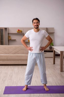 Genç adam evde spor yapıyor.