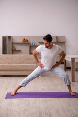 Genç adam evde spor yapıyor.