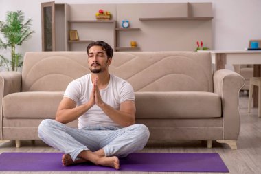 Genç adam evde spor yapıyor.