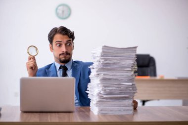 Ofisteki aşırı işten memnun olmayan genç bir erkek işçi.