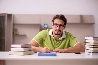 Evde okuyan genç bir erkek öğrenci.