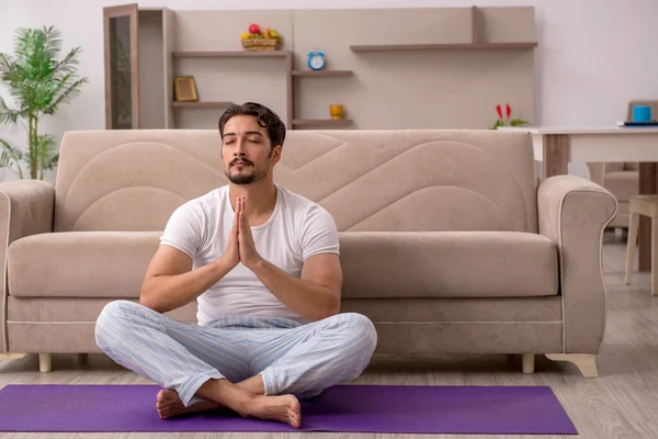 Genç adam evde spor yapıyor.