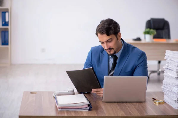 Giovane dipendente maschio infelice con un lavoro eccessivo in ufficio — Foto Stock