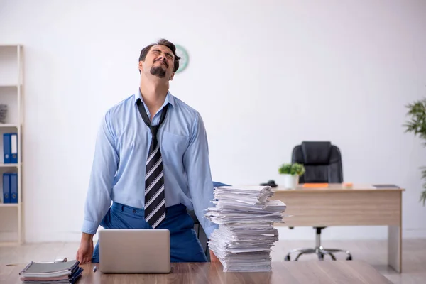 Jovem funcionário masculino infeliz com excesso de trabalho no escritório — Fotografia de Stock