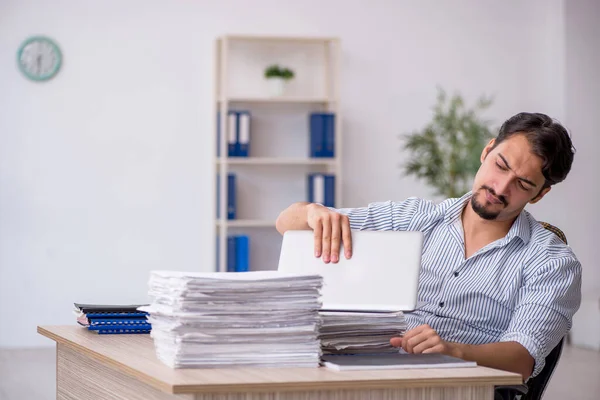 Ofisteki aşırı işten memnun olmayan genç bir erkek işçi.