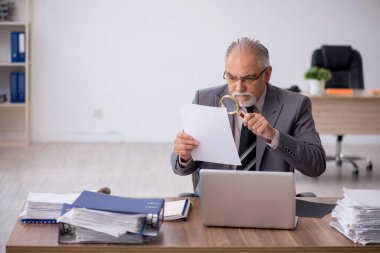 Ofiste çalışan yaşlı bir erkek.