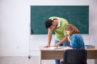 Genç öğretmen ve öğrenci sınıfta.