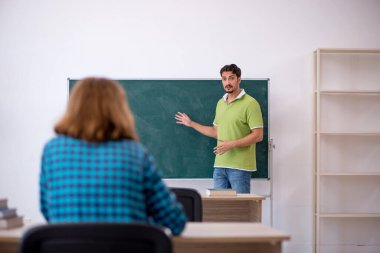 Genç öğretmen ve öğrenci sınıfta.