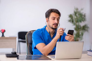 Klinikte çalışan genç erkek doktor.