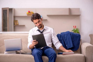 Genç erkek çalışan salgın sırasında evden çalışıyor.