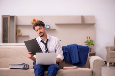 Genç erkek çalışan salgın sırasında evden çalışıyor.