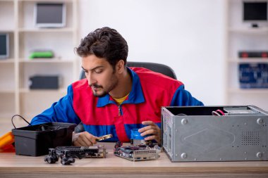 Bilgisayar tamir eden genç bir erkek tamirci.