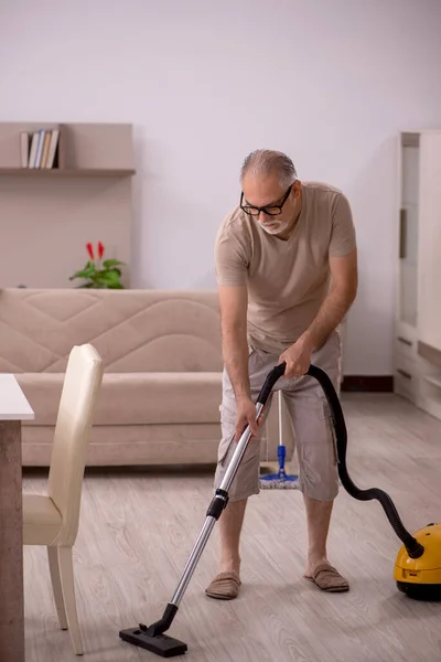 Staruszek robi prace domowe w domu — Zdjęcie stockowe