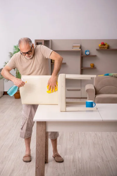 Oude man doet huishoudelijk werk thuis — Stockfoto