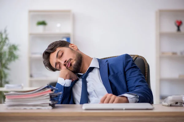 Jovem funcionário masculino extremamente cansado no escritório — Fotografia de Stock