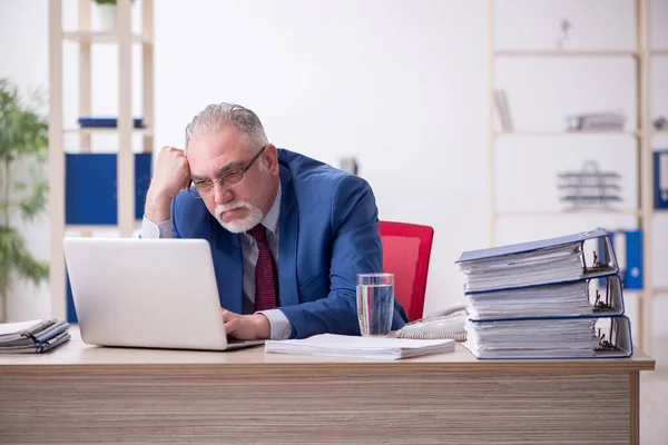 Velho empregado masculino e muito trabalho no escritório — Fotografia de Stock