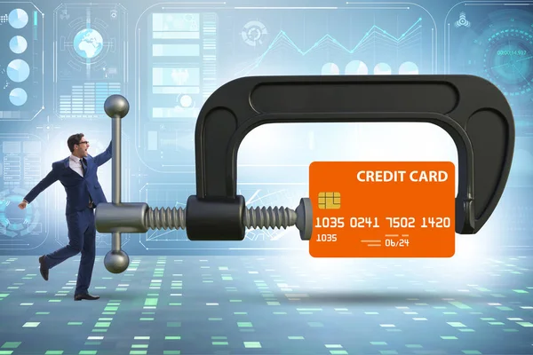 Concept of credit card debt with clamp and businessman — Stock fotografie