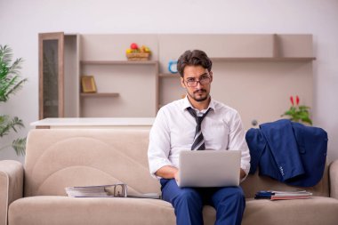 Genç erkek çalışan salgın sırasında evden çalışıyor.