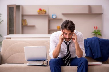 Genç erkek çalışan salgın sırasında evden çalışıyor.