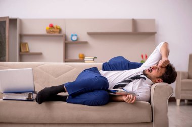 Genç erkek çalışan salgın sırasında evden çalışıyor.