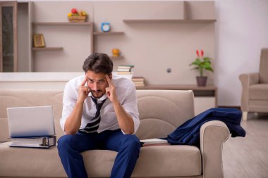 Genç erkek çalışan salgın sırasında evden çalışıyor.