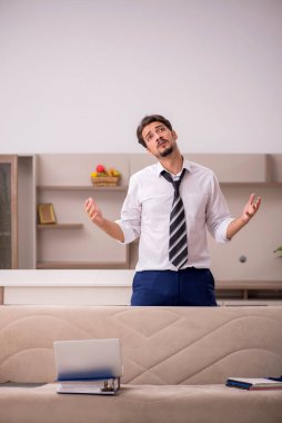 Genç erkek çalışan salgın sırasında evden çalışıyor.