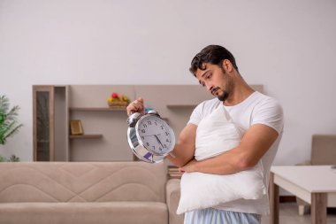 Evde spor egzersizleri yapan genç adam, zaman yönetimi konusunda hemfikir.