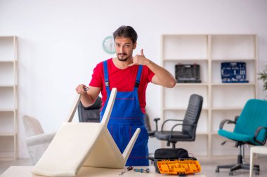 Genç erkek marangoz atölyede çalışıyor.